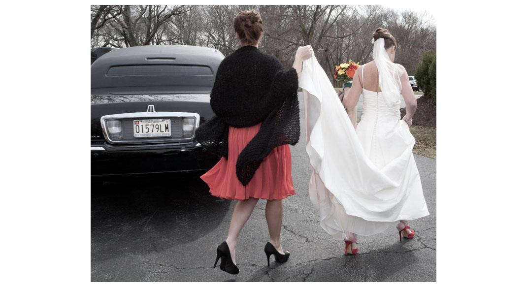 The Maid of Honor helping the bride to the limo